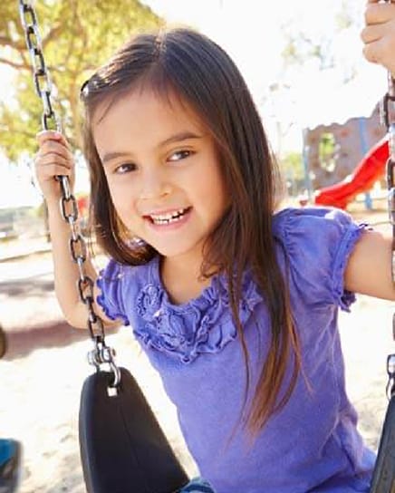 Young girl smiling on swings